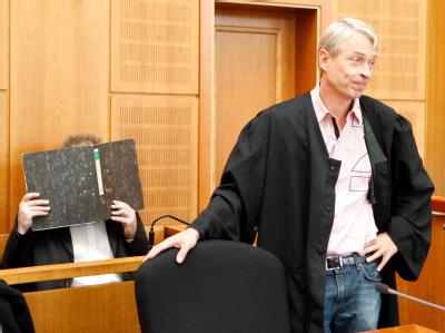 Der wegen Mordes angeklagte Olaf H. hält sich hinter seinem Anwalt einen Aktenordner vor das Gesicht. Fortsetzung Mirco-Prozess