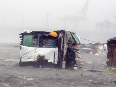 Ein Bewohner untersucht seine von Wellen beschädigte Hütte in einem Slum-Viertel in Manila. Taifun 'Nesat'