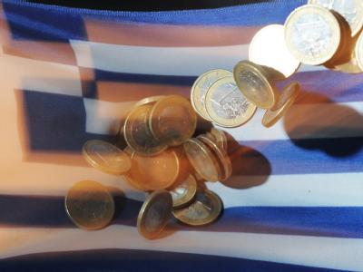 Euro-Münzen vor Griechenland-Fahne: Griechenland zapft eine letzte Geldreserve an und hat nun doch Geld bis Mitte November. Griechenland-Krise