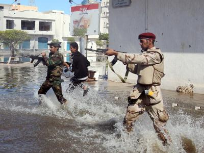 Schusswechsel auf einer überfluteten Straße in Sirte. Foto: Mohamed Messara Schießerei