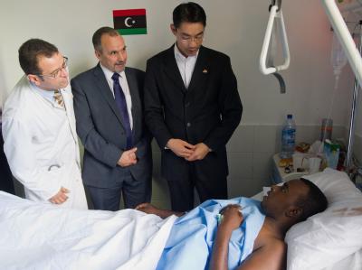 Bundeswirtschaftsminister Philipp Rösler (r) und der libysche Gesundheitsminister Naji Barakat (M) stehen in einem Krankenhaus in Tripolis am Bett eines Verwundeten. Foto: Hannibal Rösler besucht Libyen