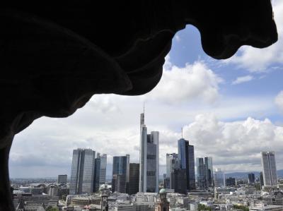 Wie ein dunkler Schatten rahmt ein Fassadenteils des Doms die Bankenskyline von Frankfurt am Main ein. Die Ratingagentur Fitch droht einer ganzen Reihe von Großbanken mit der Abstufung ihrer Kreditwürdigkeit. Foto: Boris Roessler Fitch droht Großbanken mit Abstufung