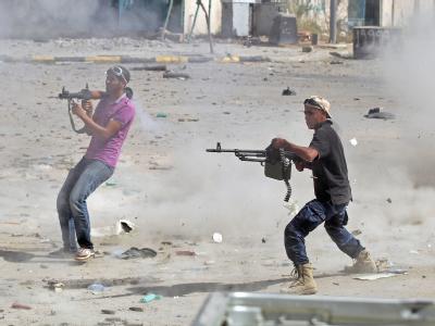 Kämpfer des Übergangsrates bei einem Gefecht gegen die letzten Getreuen des gestürzten Diktators. Foto: Mohamed Messara Kampf in Sirte