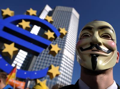 Ein mit einer Guy-Fawkes-Maske verkleideter Demonstrant steht während einer Kundgebung vor der Europäischen Zentralbank in Frankfurt am Main. Foto: Arne Dedert Protest in Frankfurt