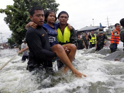 Thailändische Soldaten tragen eine Frau durch die Fluten. Foto: Rungroj Yongrit Flut in Thailand