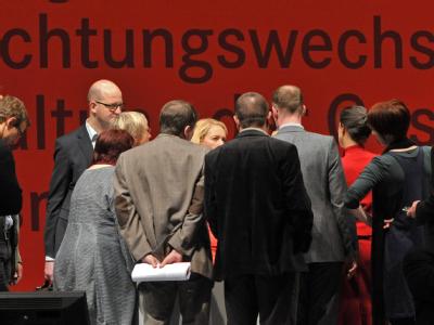 Delegierte diskutieren auf dem Bundesparteitag der Linken in Erfurt auf der Bühne. Foto: Martin Schutt, dpa Bundesparteitag der Linken in Erfurt