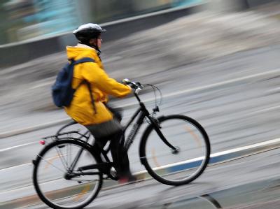 Der Umfrage zufolge zieht sich das Ja zur Helmpflicht durch alle Bevölkerungsgruppen. Foto: Hannibal, dpa Radfahrerin mit Helm