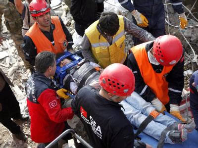 Rettungskräfte bergen einen verletzten Jungen aus den Trümmern, die das Erdbeben hinterlassen hat. Foto: Tolga Bozoglu Bergung