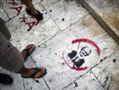 Ein Graffiti mit der durchgestrichenen Abbildung von Ministerpräsident Giorgos Papandreou ist vor dem Parlament in Athen auf den Boden gesprüht. Archivfoto: Arno Burgi Referendum in Griechenland geplant