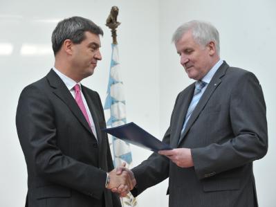 Der bayerische Ministerpräsident Horst Seehofer (r) übergibt dem neuen Finanzminister Markus Söder seine Ernennungsurkunde. Foto: Andreas Gebert Markus Söder und Horst Seehofer