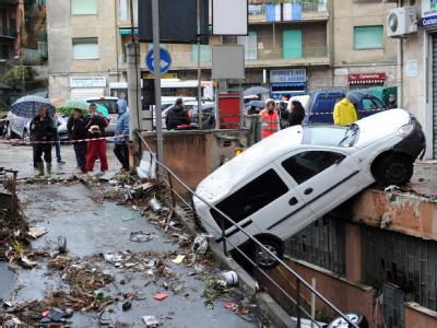 Ein Auto, das die Flut mitgerissen hatte, ist an einer Mauer hängengeblieben. Foto: Alessandro di Marco. Hängengeblieben