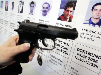 Eine mit der Mordwaffe baugleiche Pistole im Polizeipräsidium in Dortmund vor Porträts von Opfern der so genannten Döner-Morde. Archivfoto: Bernd Thissen Döner-Morde