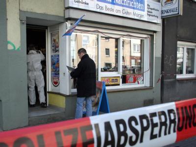 Polizeibeamte untersuchen nach einem Mord in Dortmund einen Kiosk auf Spuren am 04.04.2006. Foto: Nils Foltynowicz Deutschlandweite Mordserie
