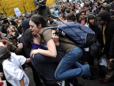 Wie US-Medien berichteten, bahnten sich etwa 750 Demonstranten durch Polizeikontrollen den Weg zurück in den Zuccotti Park. Foto: Justin Lane Über die Absperrung hinweg