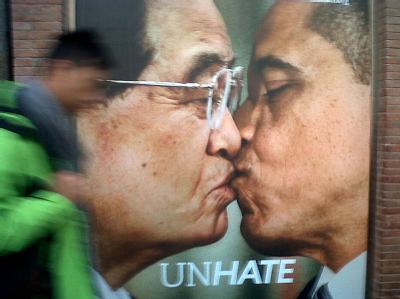 In Rom geht ein Mann an einem Plakat vorbei, das US-Präsident Barack Obama und seinen chinesischen Kollegen Hu Jintao beim Lippenkuss zeigt. Foto: Francesca Frattura Umstrittene Küsse: Hu und Obama