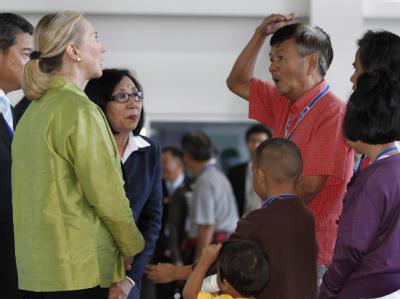 Hillary Clinton lässt sich von einem thailändischen Flutopfer berichten, wie hoch das Wasser in seinem Haus stand. Foto: Barbara Walton Clinton in Thailand