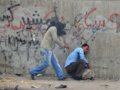Demonstranten auf dem Tahrir-Platz erholen sich von einer Tränengas-Attacke der Sicherheitskräfte. Foto: Mohamed Omar Atempause