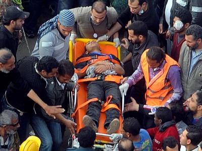 Ein Verletzter wird vom Tahrir-Platz abtransportiert. Die Proteste in Kairo dauern an, erneut wurde offenbar ein Demonstrant getötet. Foto: Mohamed Omar Protestler auf dem Tahrir-Platz