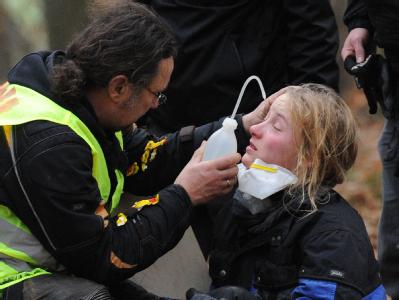 Ein Mann spült bei Göhrde in Niedersachsen die Augen einer Castor-Gegnerin, die von der Polizei mit Reizmitteln besprüht wurde. Foto: Julian Stratenschulte Verletzte Castor-Gegnerin