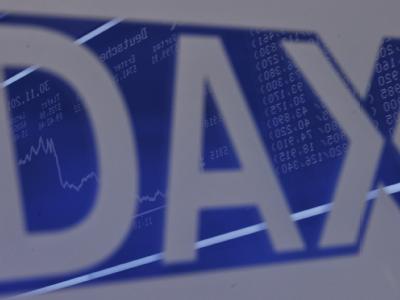 Die Dax-Kurve spiegelt sich im Handelssaal der Wertpapierbörse in Frankfurt am Main in einem Schriftzug. Foto: Arne Dedert/Archiv Dax