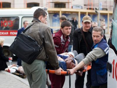 Rettungskräfte und Passanten tragen im April 2011 in Minsk einen Verletzten zu einem Rettungswagen. Foto: Anton Motolko Anschlag in Minsk