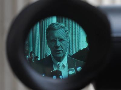 Christian Wulff im Okular einer Kamera. Die Affäre um einen Privat-Kredit ist noch nicht ausgestanden. Foto: Jochen Lübke/ Archiv Christian Wulff