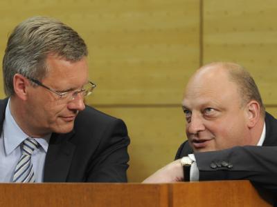 Niedersachsens damaliger Ministerpräsident Christian Wulff unterhält sich im Landtag in Hannover mit dem damaligen Regierungssprecher Olaf Glaeseker. Foto: Holger Hollemann/Archiv Glaeseker und Wulff
