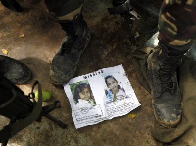 Soldaten betrachten das Bild einer Vermissten nach der Sturzflut im Süden der Philippinen. Foto: Francis R. Malasig Suche nach Vermissten