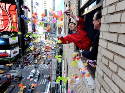 Tim Tompkins, Chef der Times Square Alliance(L), und Jeffrey Strauss von Countdown Entertainment testen am New Yorker Times Square schon einmal die Windverhältnisse für den Konfetti-Regen. Foto: Justin Lane Konfetti-Test