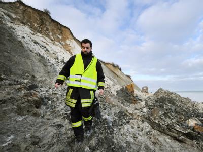 Einsatzleiter Daniel Hartlieb überprüft die Unglückstelle unter dem Steilufer von Kap Arkona in der Gemeinde Putgarten auf der Insel Rügen. Die Suche nach dem verschütteten Mädchen auf der Insel Rügen ist wegen Hochwassers vorerst eingestellt worden. Foto Suche eingestellt
