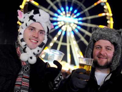 Die Freunde Steven (l) und Charlie aus London sind am Silvesterabend in Berlin gut verpackt auf der Festmeile unterwegs. Foto: Britta Pedersen Jahreswechsel 2012 - Brandenburger Tor