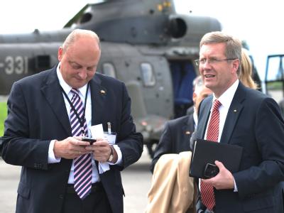 Christian Wulff (r) und sein damaliger Sprecher Olaf Glaeseker im Herbst 2010 auf einem Flugplatz in Lausanne. Foto: Rainer Jensen Wulff und Glaeseker