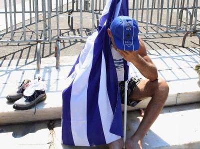 Ein Demonstrant mit einer griechischen Flagge am Rande einer Demonstration in Athen. Foto: Pantelis Saitas/Archiv Griechenland in der Krise