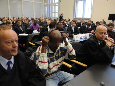 Die angeklagten zehn mutmaßlichen Piraten aus Somalia bei Prozessbeginn am 22.11.2010 mit ihren Anwälten im Gerichtssaal in Hamburg. Foto: Marcus Brandt Piraten-Prozess
