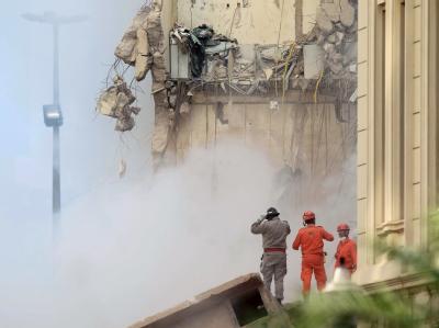 Feuerwehrleute suchen in den Trümmern der eingestürzten Häuser nach Überlebenden. Foto: Marcelo Sayao Trümmerlandschaft in Rio