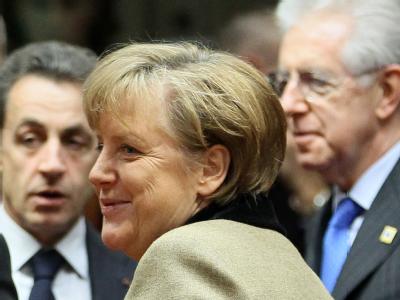 Kanzlerin Merkel auf dem EU-Sondergipfel in Brüssel. Im Hintergrund unterhalten sich der talienische Ministerpräsidenten Monti (r) und der französische Präsident Sarkozy. Foto: Olivier Hoslet Kanzlerin Merkel auf dem EU-Sondergipfel in Brüssel