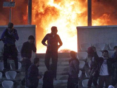 Fußball-Fans verlassen das Stadion in Kairo, nachdem ein Spiel abgebrochen wurde. Zuvor war bekannt geworden, dass es Krawalle in Port Said gegeben habe. Daraufhin brach Feuer im Kairoer Stadion aus. Foto: Ahmed Khaled Feuer im Stadion