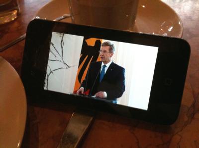 Ein Kneipenbesucher in Hannover verfolgt die Pressekonferenz von Bundespräsident Christian Wulff auf einem smartphone. Foto: Jochen Lübke Rücktritt von Bundespräsident Wulff