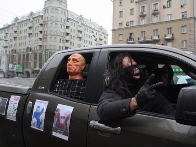 Maskiert und mit Putin-Puppe auf dem Rücksitz protestieren Moskauer für faire Wahlen. Foto: Sergei Ilnitsky Protest in Moskau