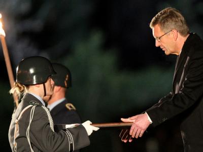 Ex-Bundespräsident Christian Wulff nimmt beim Großen Zapfenstreich ein Geschenk entgegen. Foto: Wolfgang Kumm Großer Zapfenstreich für Wulff