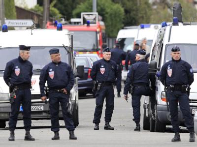 Polizisten haben alle Straßen um die Wohnung des mutmaßlichen Mörders abgeriegelt. Foto: Guillaume Horcajuelo Kein Durchkommen