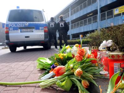 Blumen und Kerzen erinnern vor dem Tatort an die ermordete Elfjährige. Foto: Ingo Wagner Blumen und Kerzen