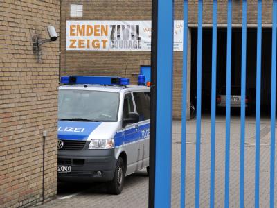 Ein Polizeifahrzeug auf dem Gelände des Polizeireviers in Emden. Im Hintergrund ist vor dem sich schließenden Tor ein Banner zu sehen, das für Zivilcourage wirbt. Foto: Michael Bahlo Mordermittlungen in Emden