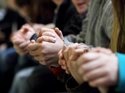 Mitschüler und Lehrer gedenken in einer bewegenden Trauerfeier der ermordeten Lena. Foto: Karlheinz Krämer/Stadt Emden An den Händen halten