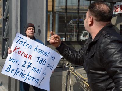 Ein Mann protestiert am Potsdamer Platz in Berlin gegen die kostenlose Koran-Verteilung. Foto: Britta Pedersen Protest in Berlin