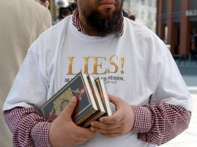 Ein Islamist verteilt in Berlin kostenlose Koran-Exemplare an Passanten. Foto: Britta Pedersen Islamist in Berlin