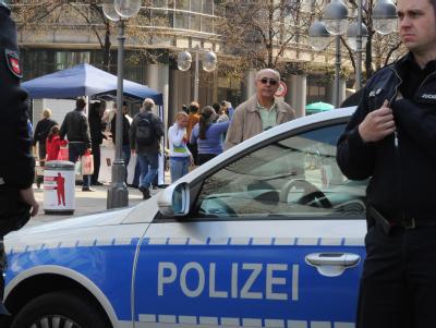 Polizeibeamte beobachten in Hannover das kostenlose Verteilen von Koran-Exemplaren an Passanten. Foto: Julian Stratenschulte Koran-Verteilung