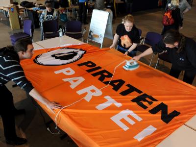 Letzte Vorbereitungen: Ein Mitarbeiter bügelt in Neumünster eine Fahne mit dem Logo der Piratenpartei. Foto: Carsten Rehder Vorbereitungen auf Bundesparteitag der Piratenpartei