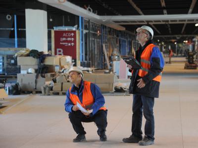 TÜV-Prüfer auf dem neuen Berliner Flughafen in Schönefeld. Foto: Bernd Settnik/Archiv TÜV-Prüfer
