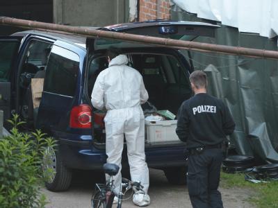 Ermittler der Spurensicherung der Polizei durchsuchen in Kiel das Gelände einer Kfz-Werkstatt. Foto: Marcus Brandt Spurensuche